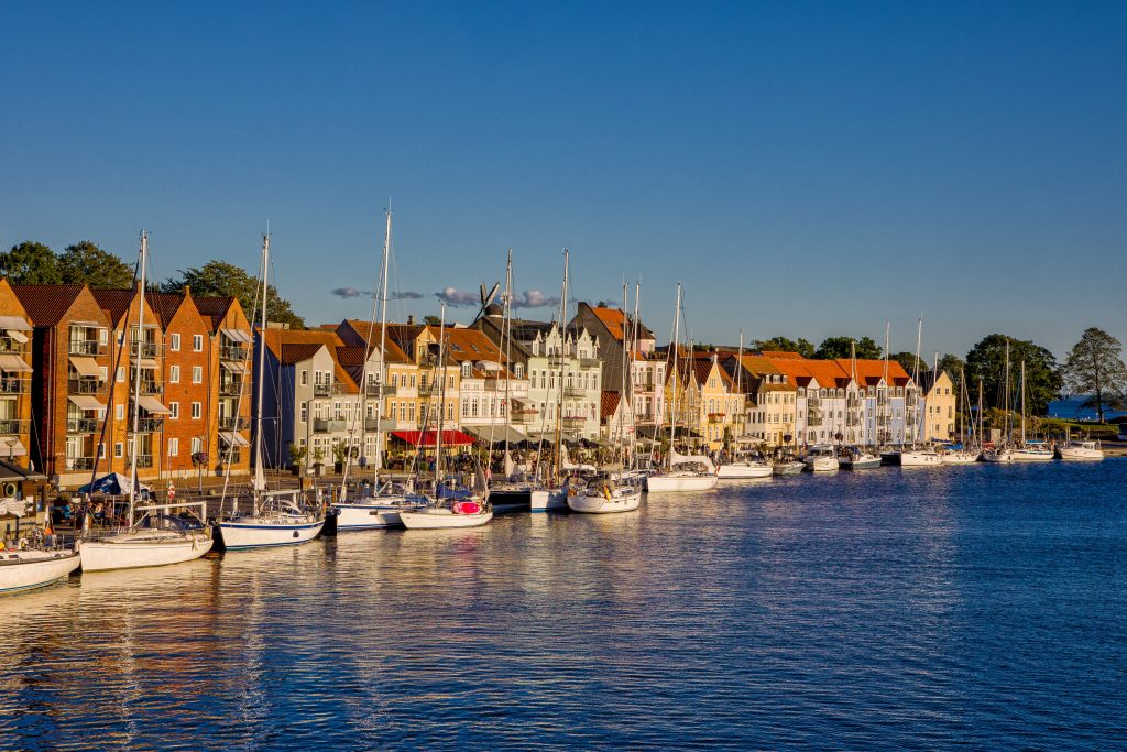skyline with blue sky and evening sunlight in the danish city of Sonderborg, overlooking the promenade with sailboats.