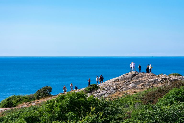 Cliff of Kullaberg mountain on the west coast of Sweden. Klippa på Kullaberg. Baltic sea in the distance behind the dramatic rocks. Sunshine on a warm summer day, Scandinavia.